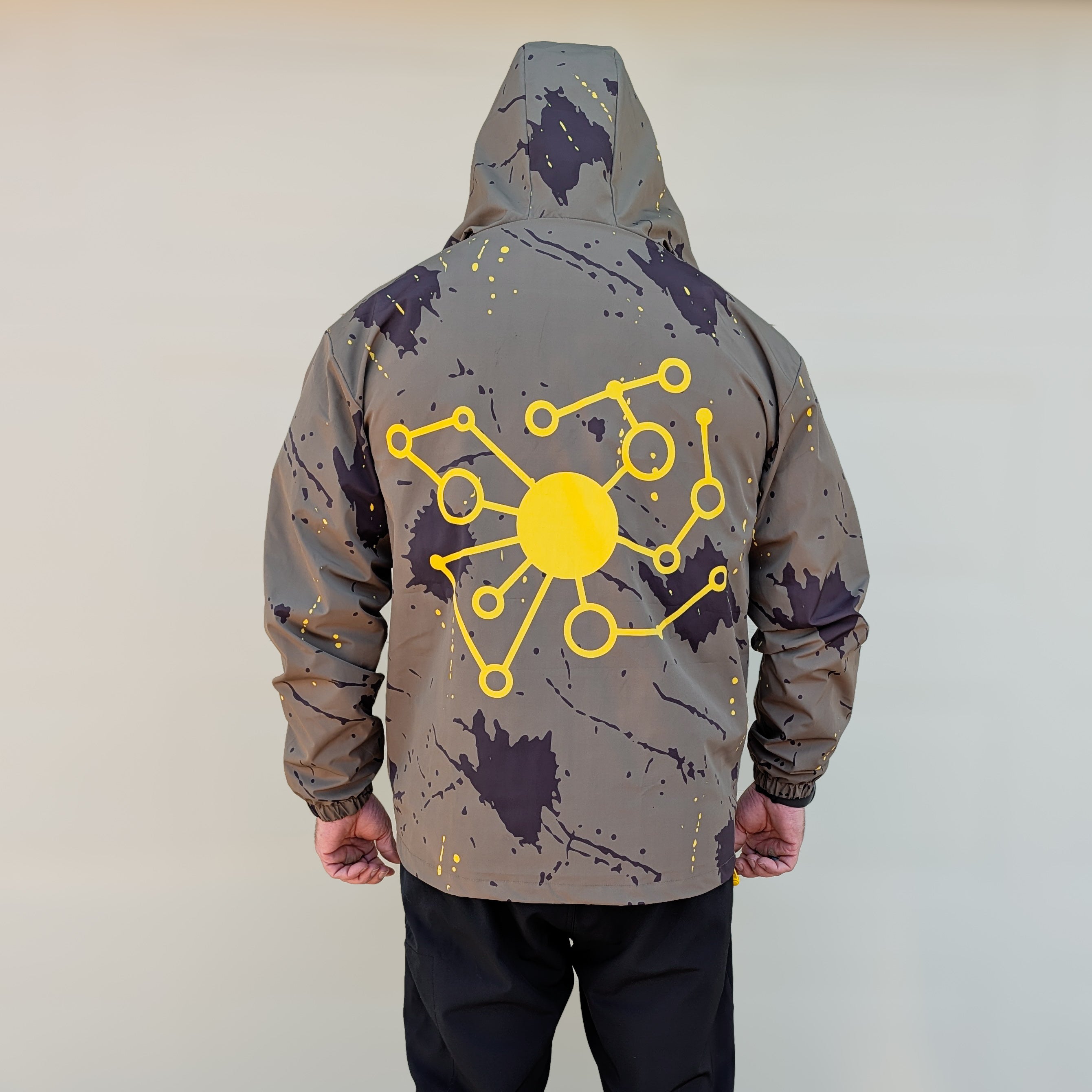 Person wearing a gray hoodie with a yellow geometric design on the back.