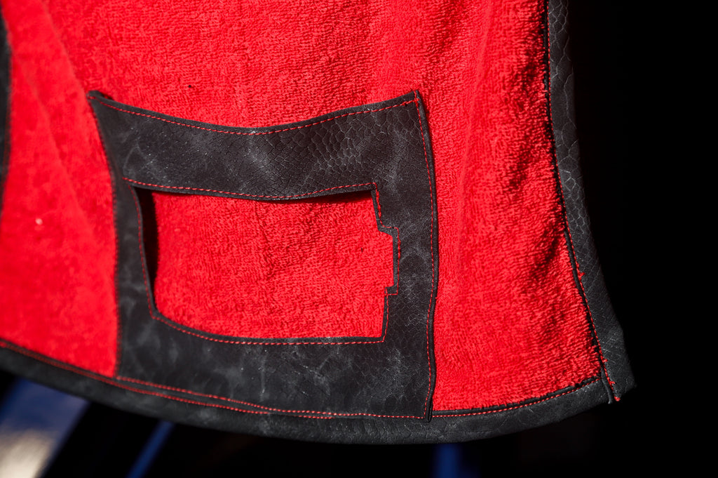 Close-up of a Media Towels red fabric with a black pocket detail on a gym machine.