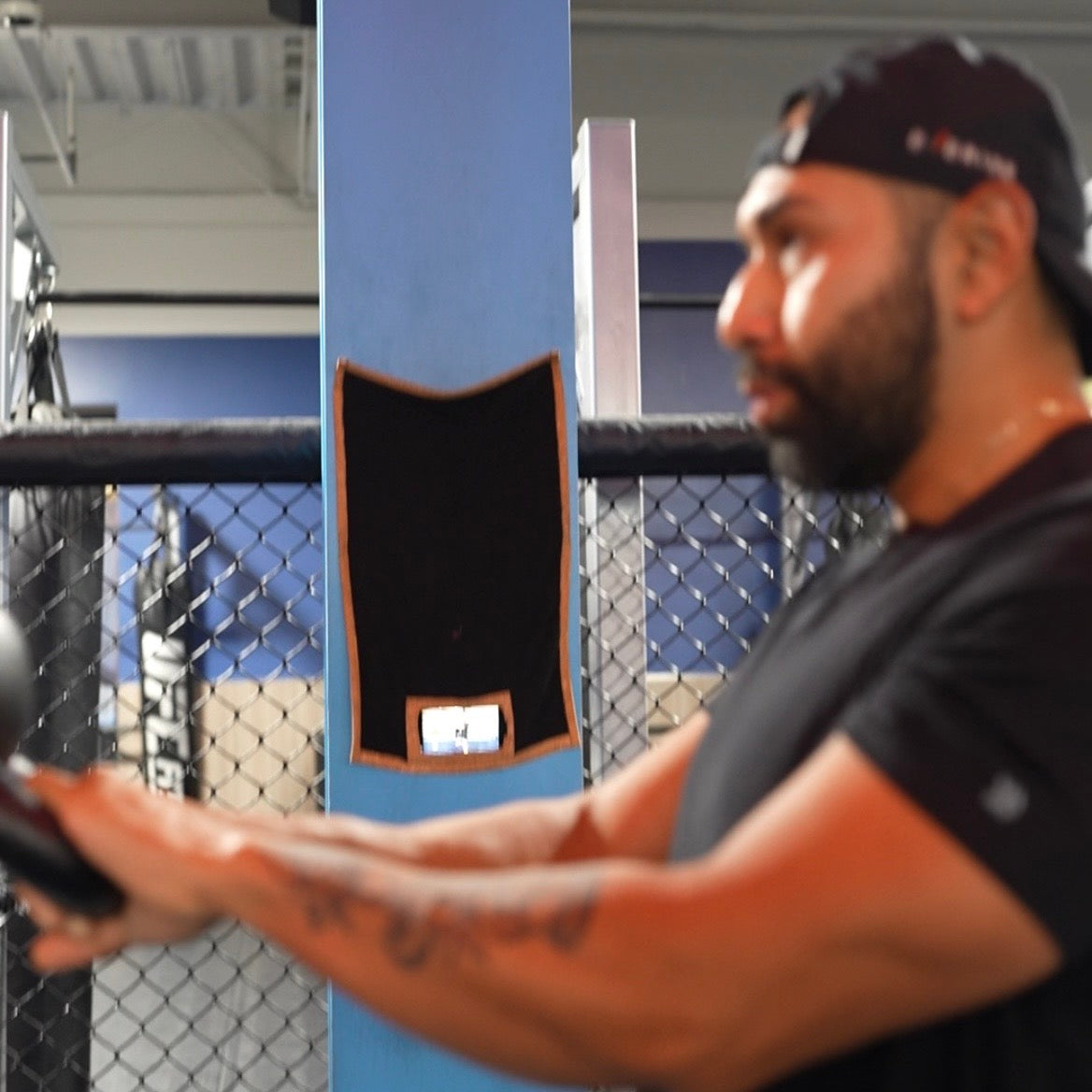 Man demonstrating kettle bell swings while recording training video using Media Towel to hold phone.