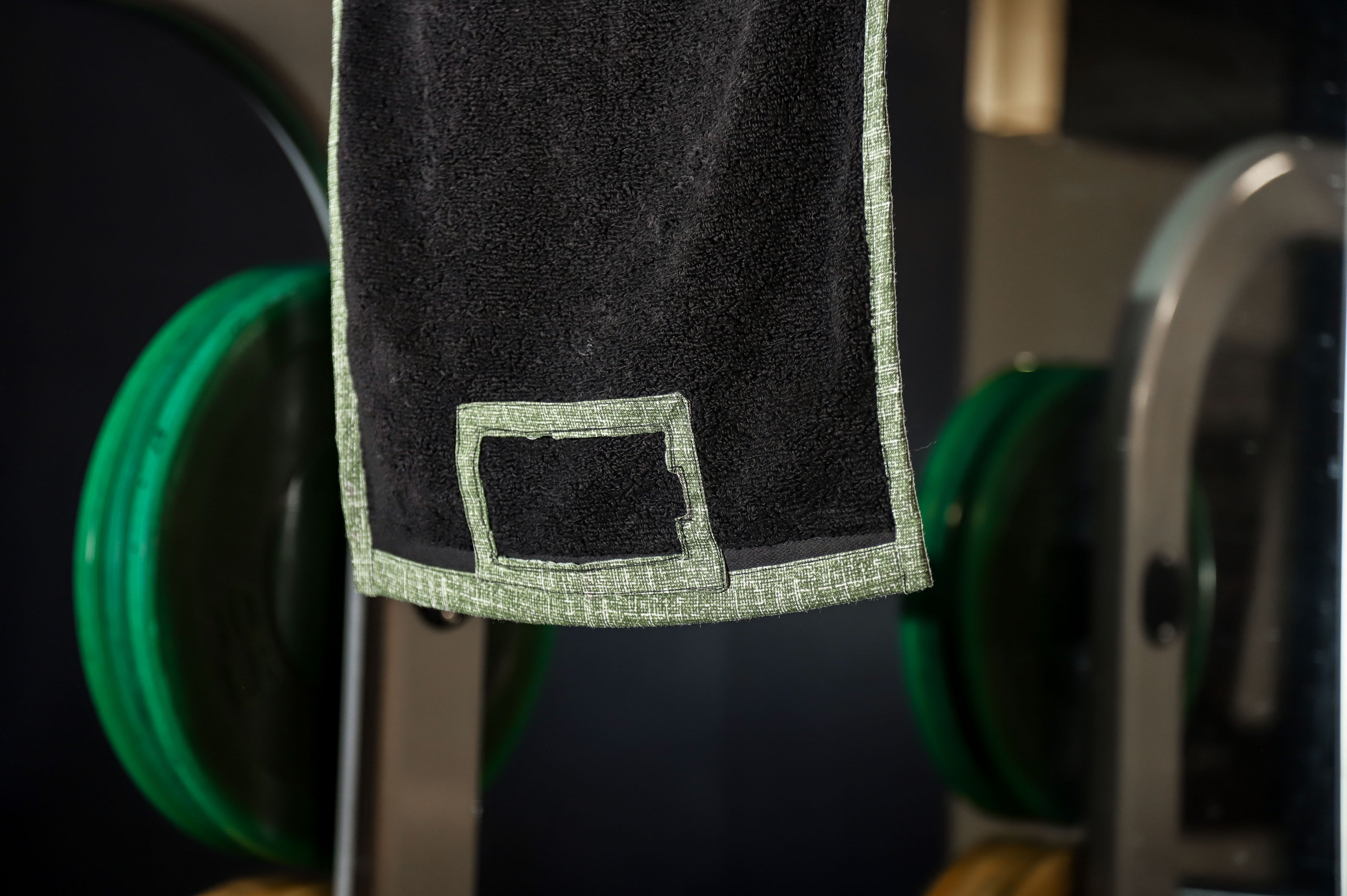 Close-up of a black garment with green accents on a blurred background