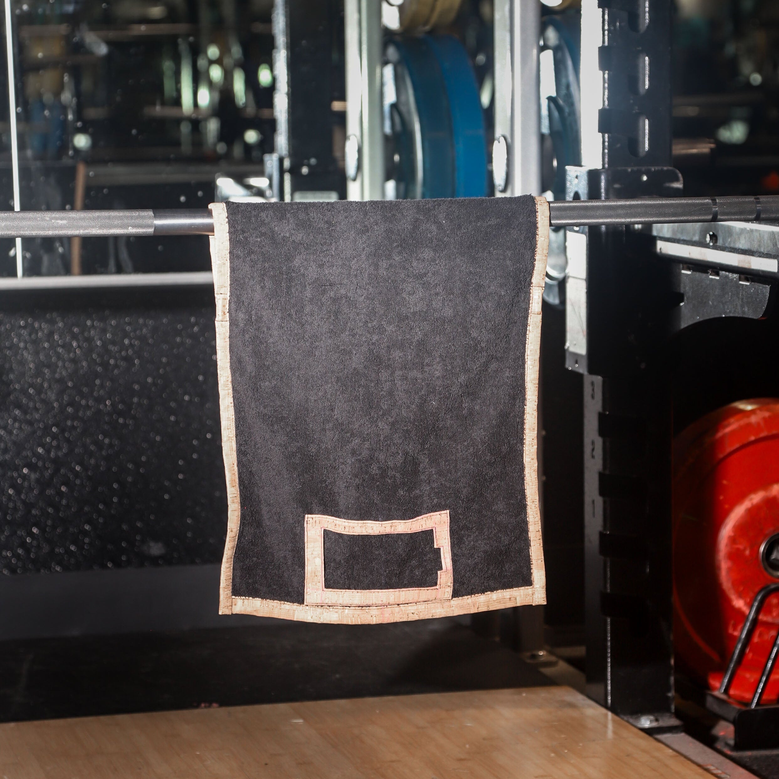Black towel hanging on a barbell in a gym setting