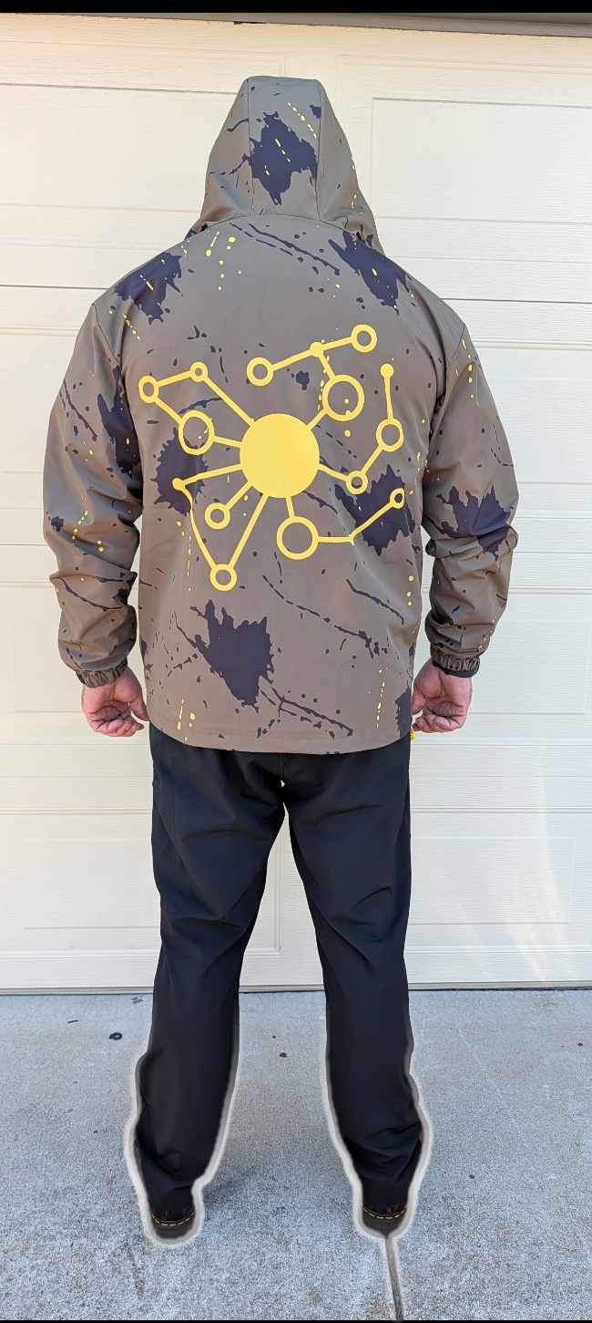 Pivot Storm Jacket Founder Edition at REI store — olive technical shell with yellow accents, athletic fit, hood up