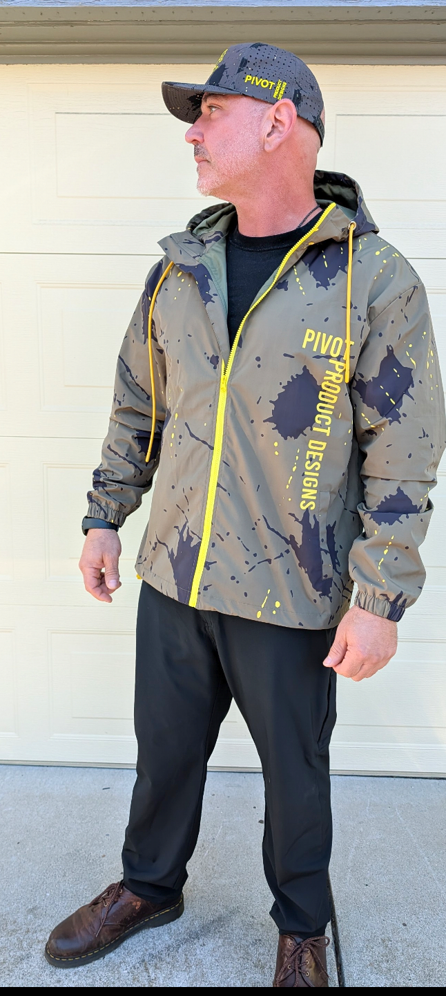 Detail of the Pivot Storm Jacket Founder Edition — yellow zippers, drawstrings, and embroidered PIVOT PRODUCT DESIGNS wordmark