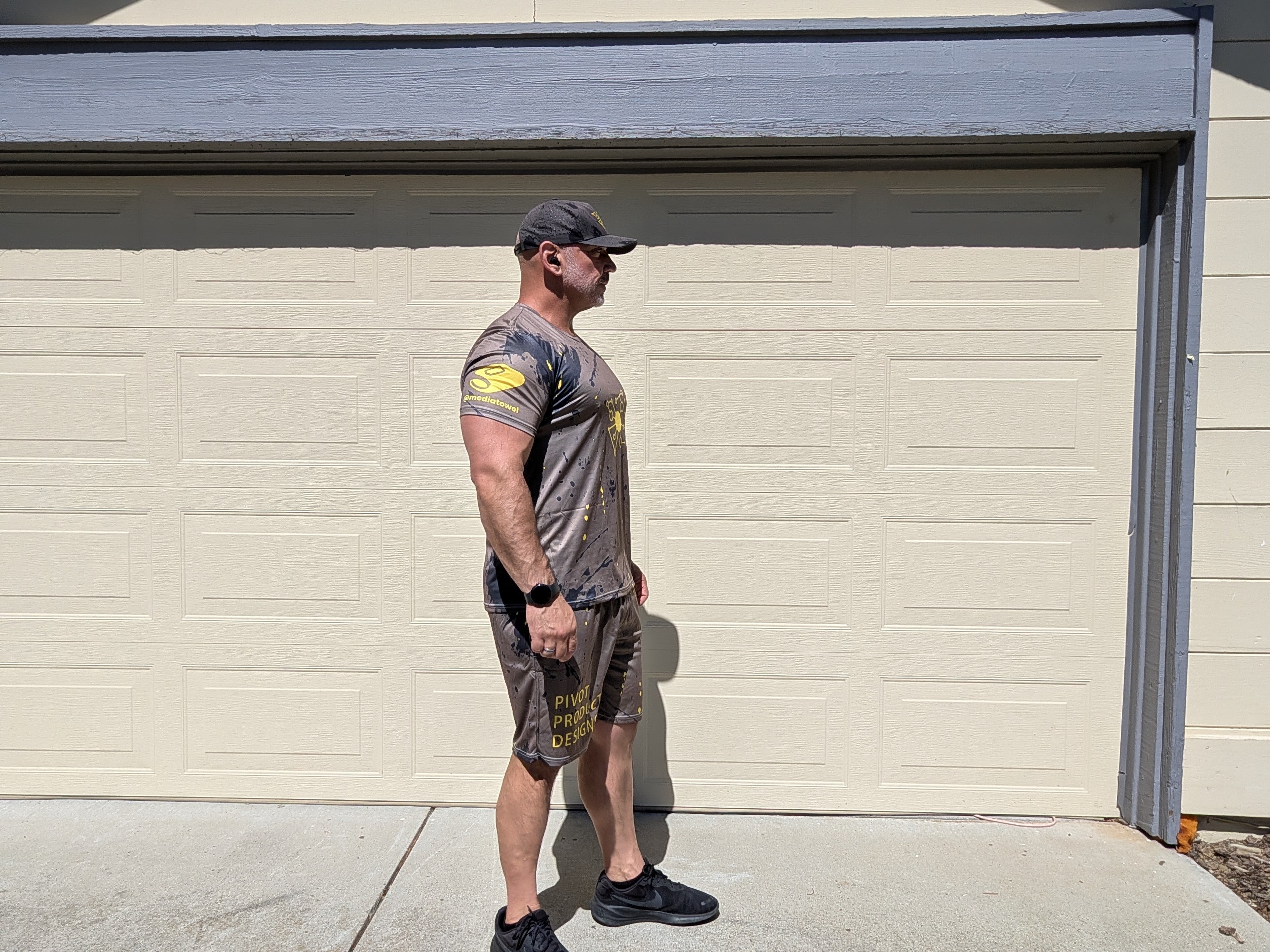Front view of the Pivot Performance Set Bundle full kit on Big Mike — matched Tee and Shorts in charcoal with yellow accents